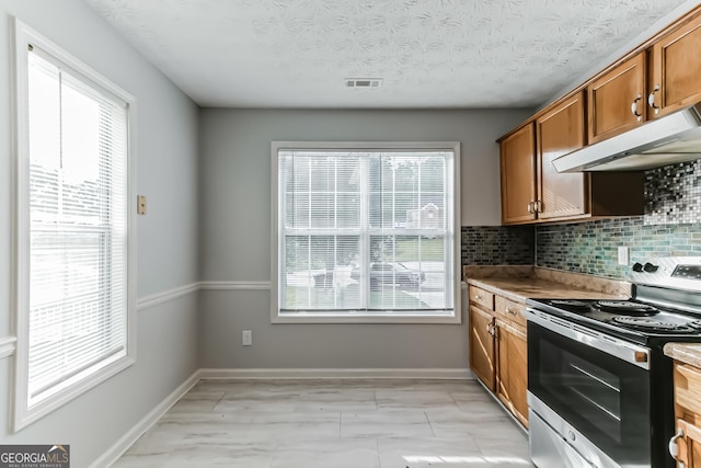 kitchen with decorative backsplash, a textured ceiling, and stainless steel range with electric stovetop