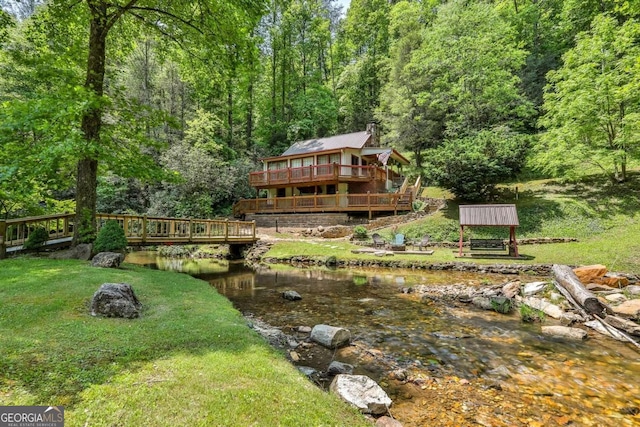 view of yard with a deck with water view