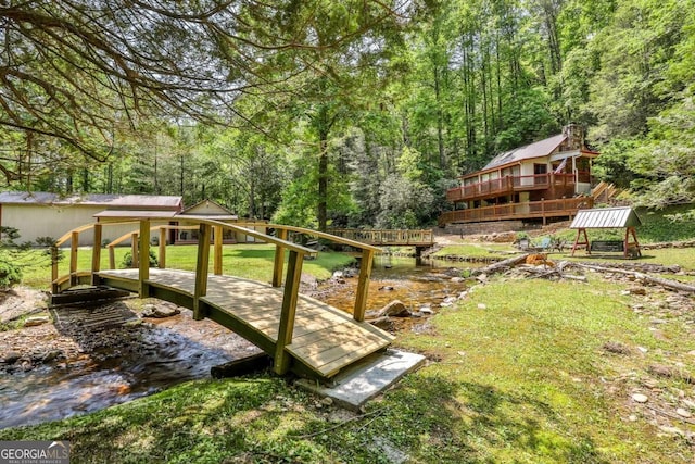 view of yard with a deck with water view