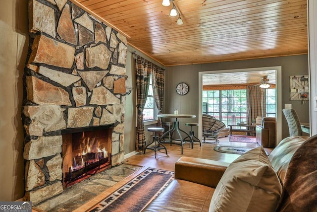 living room with wood ceiling, a fireplace, hardwood / wood-style flooring, and a healthy amount of sunlight