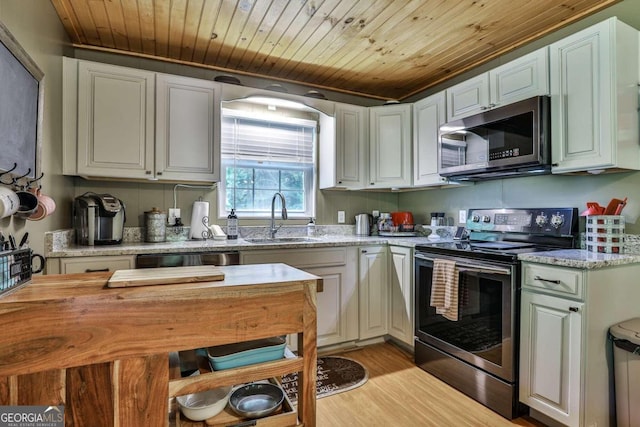 kitchen featuring appliances with stainless steel finishes, sink, light stone counters, light hardwood / wood-style floors, and wooden ceiling