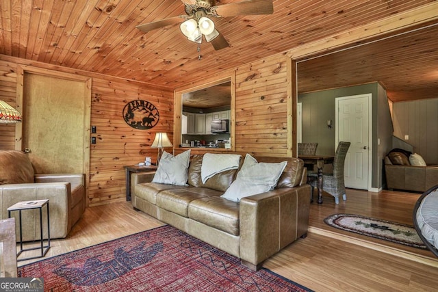 living room featuring wood walls, light wood-type flooring, and wood ceiling