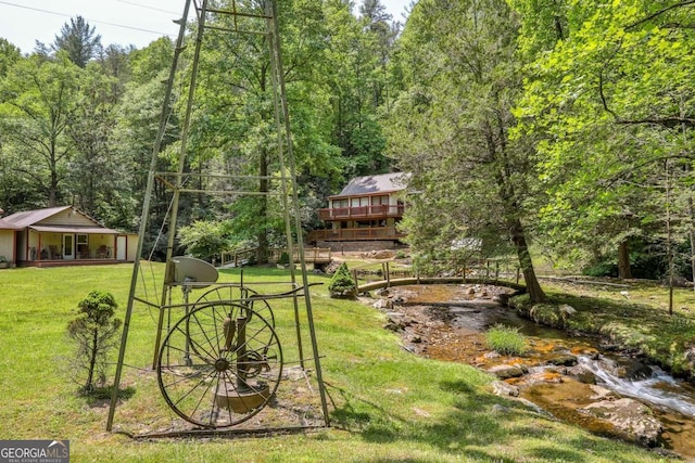 view of yard with a deck with water view