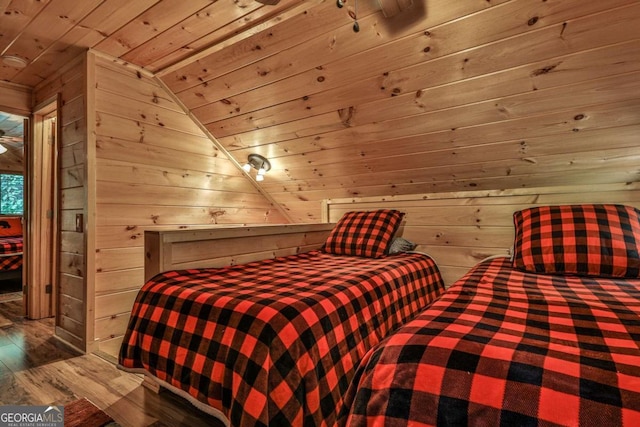 bedroom with wooden ceiling, lofted ceiling, wooden walls, and hardwood / wood-style floors