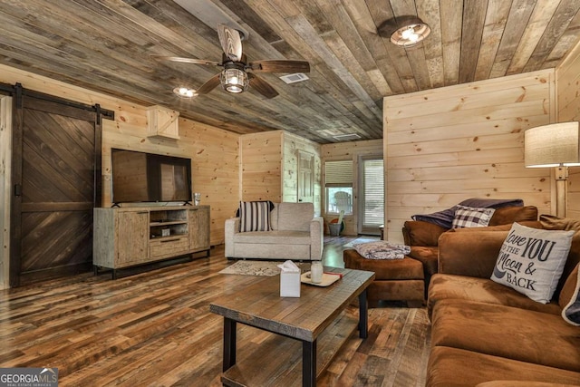 living room with ceiling fan, wooden walls, hardwood / wood-style floors, a barn door, and wood ceiling