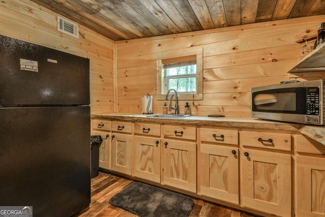 kitchen with wood ceiling, dark wood-type flooring, and black refrigerator