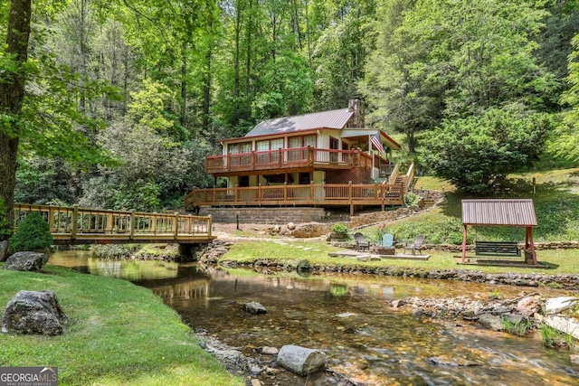 back of property with a deck with water view