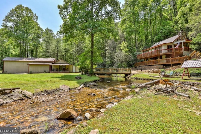 view of yard with a deck with water view