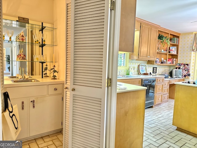 kitchen featuring light tile patterned floors, cooktop, tasteful backsplash, and sink