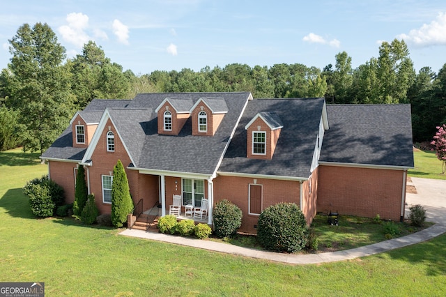 new england style home featuring a porch and a front yard