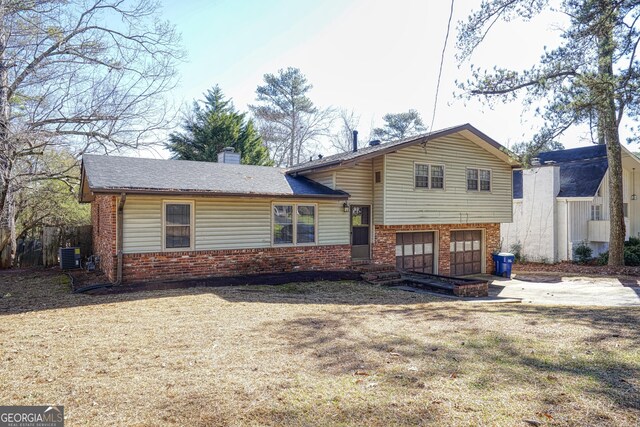 split level home featuring a front yard and a garage