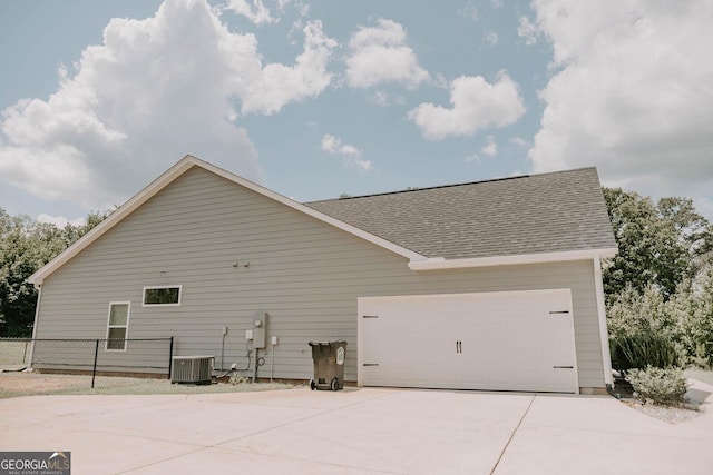 view of side of home featuring a garage and central air condition unit