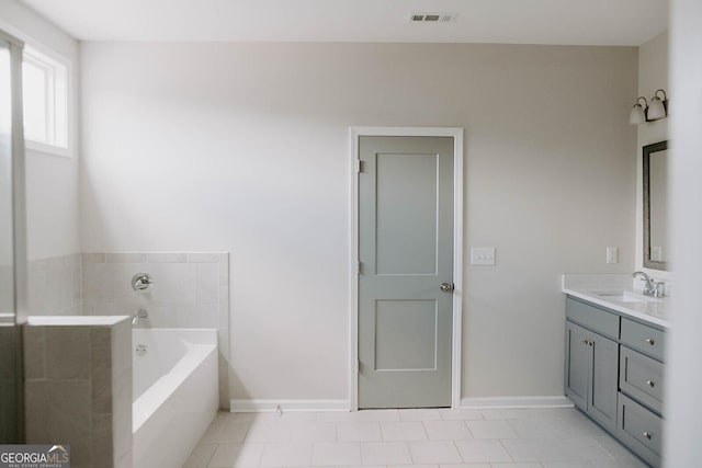 bathroom featuring tile patterned flooring, vanity, and a bathing tub