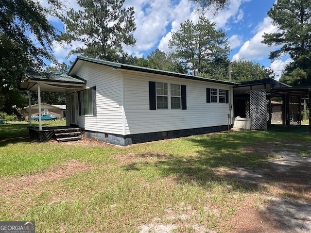 view of home's exterior featuring a carport and a yard