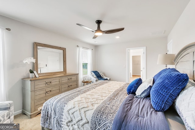 bedroom with light carpet, ceiling fan, visible vents, and baseboards