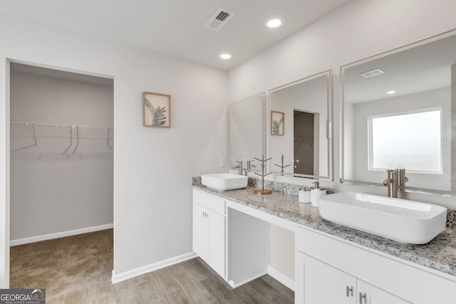 full bath with a spacious closet, a sink, visible vents, and recessed lighting