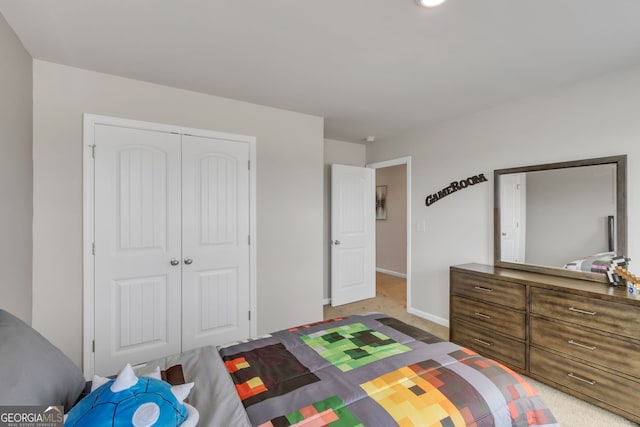 bedroom featuring light carpet, baseboards, and a closet