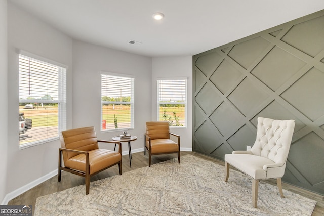 sitting room with baseboards, visible vents, wood finished floors, and recessed lighting