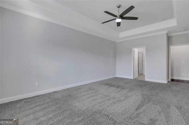 interior space featuring a tray ceiling, ceiling fan, crown molding, and carpet