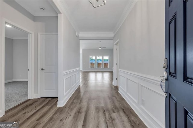 entryway featuring ceiling fan, wood-type flooring, and ornamental molding