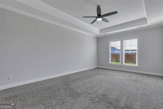 carpeted spare room with ceiling fan and a raised ceiling