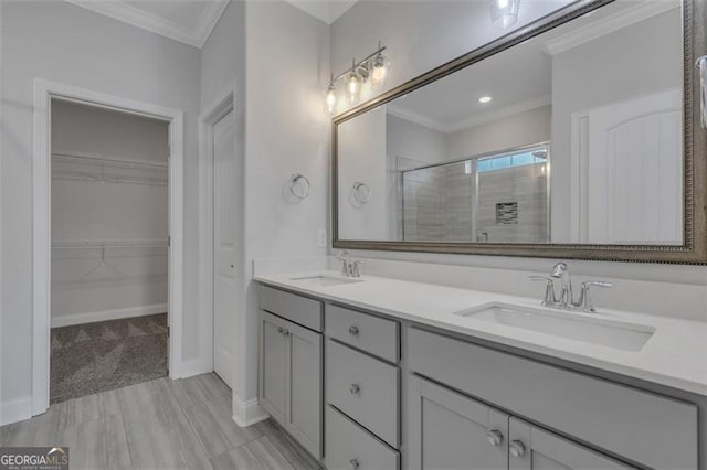 bathroom featuring ornamental molding, dual bowl vanity, and a shower with door