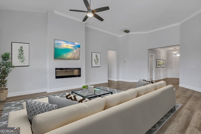 living room featuring ceiling fan, light hardwood / wood-style flooring, and ornamental molding