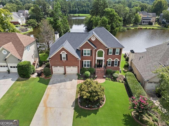 view of front of property with a front lawn, a water view, and a garage