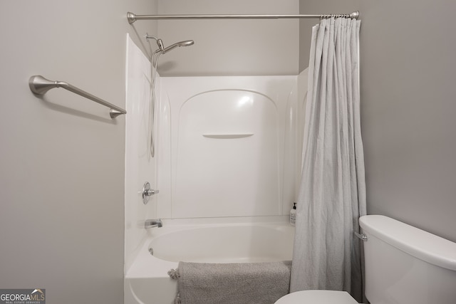 bathroom featuring shower / tub combo and toilet