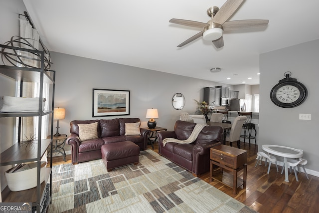 living room featuring wood-type flooring and ceiling fan