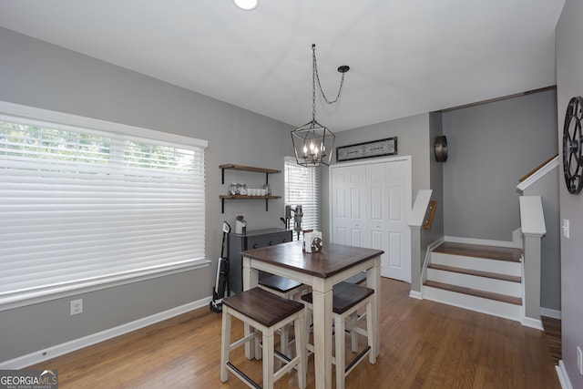 dining area with a healthy amount of sunlight, an inviting chandelier, and hardwood / wood-style floors