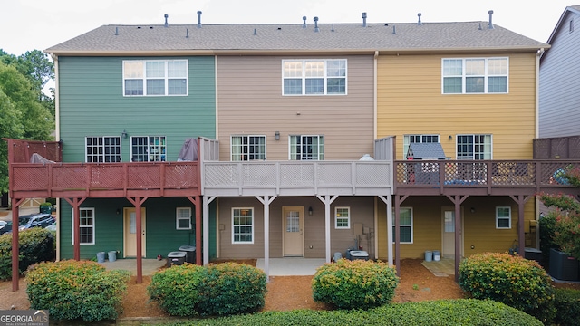 rear view of property with central AC unit and a patio