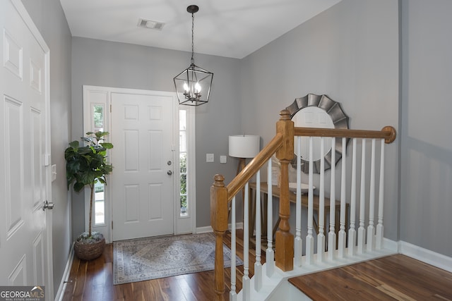 foyer entrance with an inviting chandelier, hardwood / wood-style flooring, and a healthy amount of sunlight