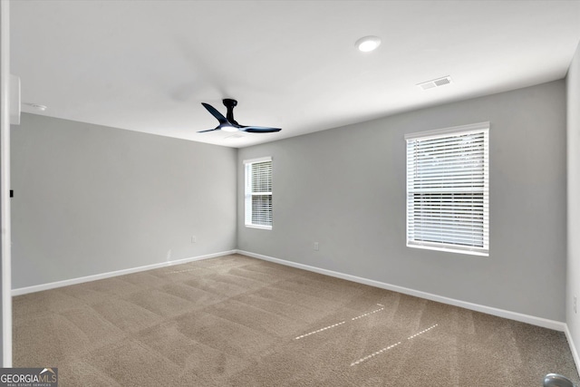 carpeted spare room featuring ceiling fan