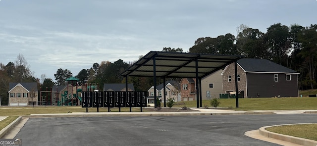 exterior space with mail boxes, a yard, and a playground