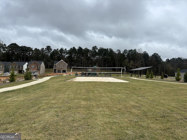 view of community with a lawn and volleyball court