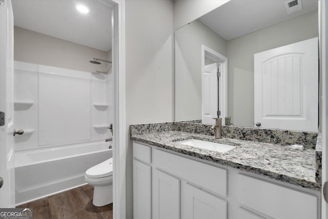 full bathroom featuring hardwood / wood-style flooring, vanity, toilet, and bathing tub / shower combination