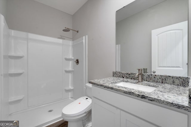 bathroom featuring walk in shower, vanity, and toilet