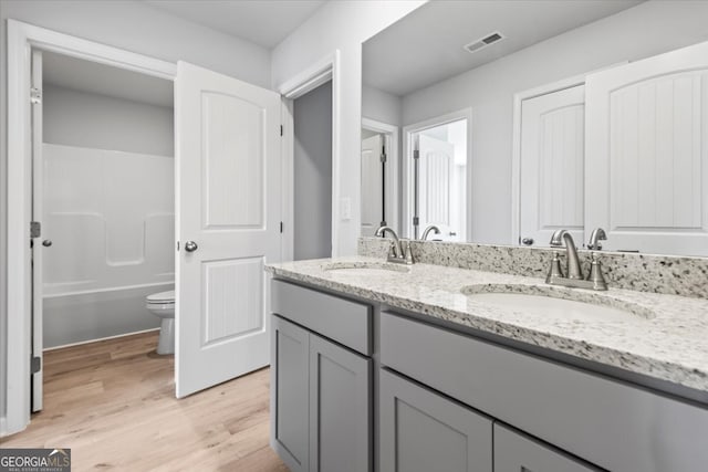 bathroom with vanity, hardwood / wood-style floors, and toilet