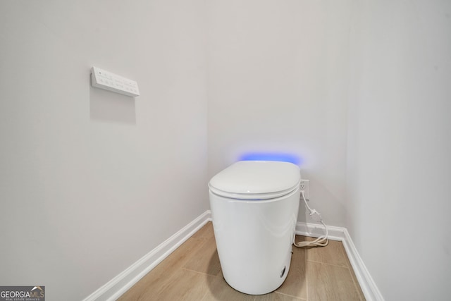 bathroom with toilet and hardwood / wood-style floors