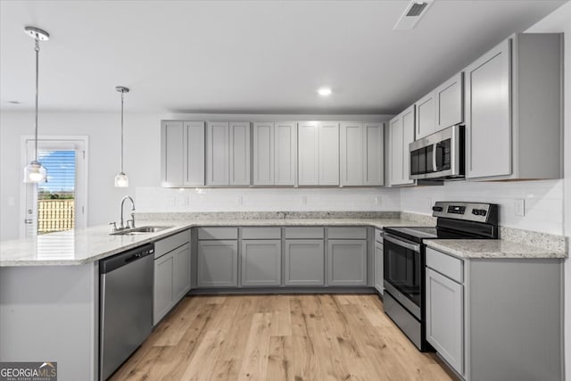 kitchen featuring pendant lighting, sink, gray cabinetry, and stainless steel appliances