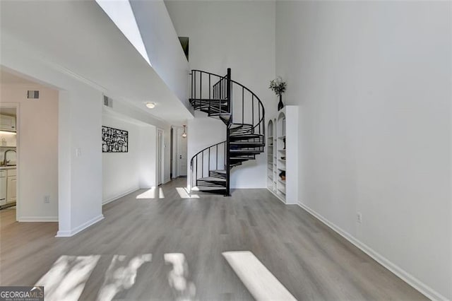 staircase featuring light hardwood / wood-style flooring and sink