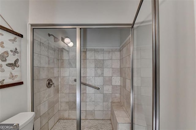 bathroom featuring an enclosed shower and toilet