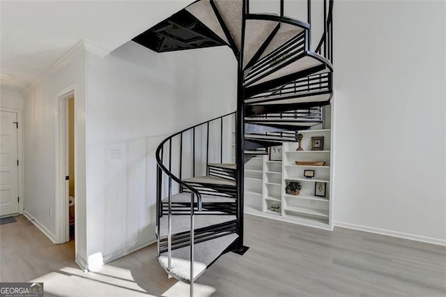 stairs featuring crown molding and hardwood / wood-style flooring