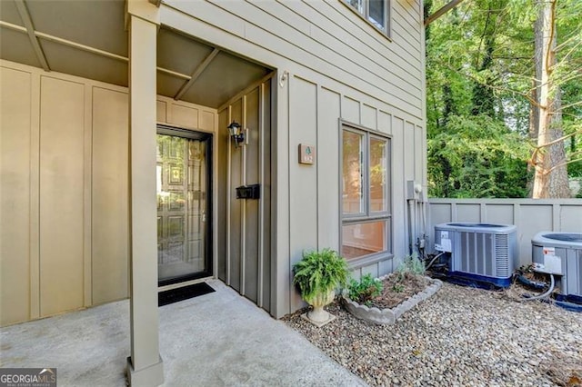 view of exterior entry featuring cooling unit and a patio area