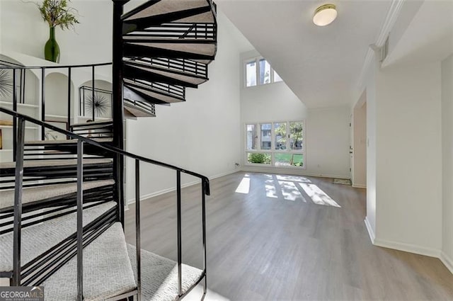 stairs with light hardwood / wood-style flooring and ornamental molding