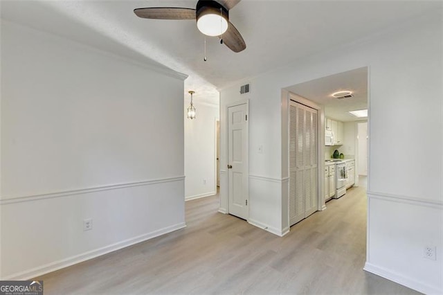 empty room featuring ceiling fan and light wood-type flooring