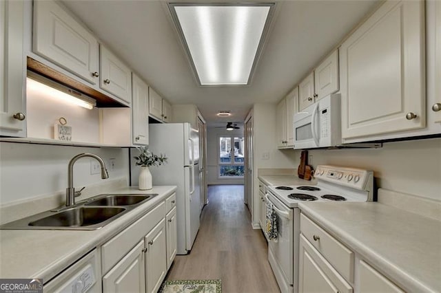 kitchen featuring white appliances, white cabinets, sink, and light hardwood / wood-style floors