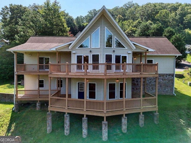 back of property featuring a wooden deck and a lawn