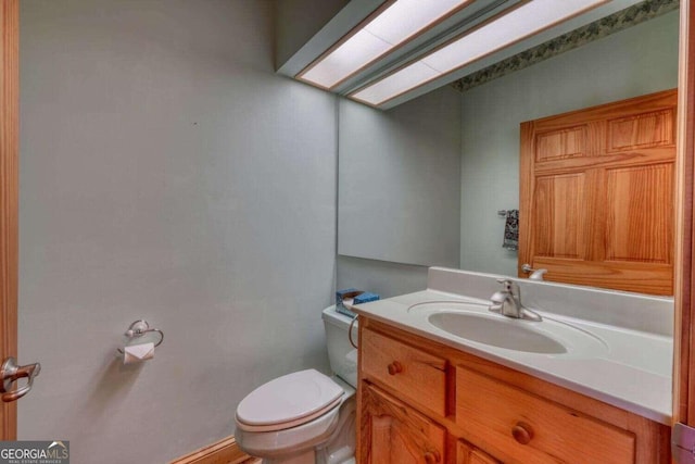 bathroom featuring vanity, toilet, and a skylight